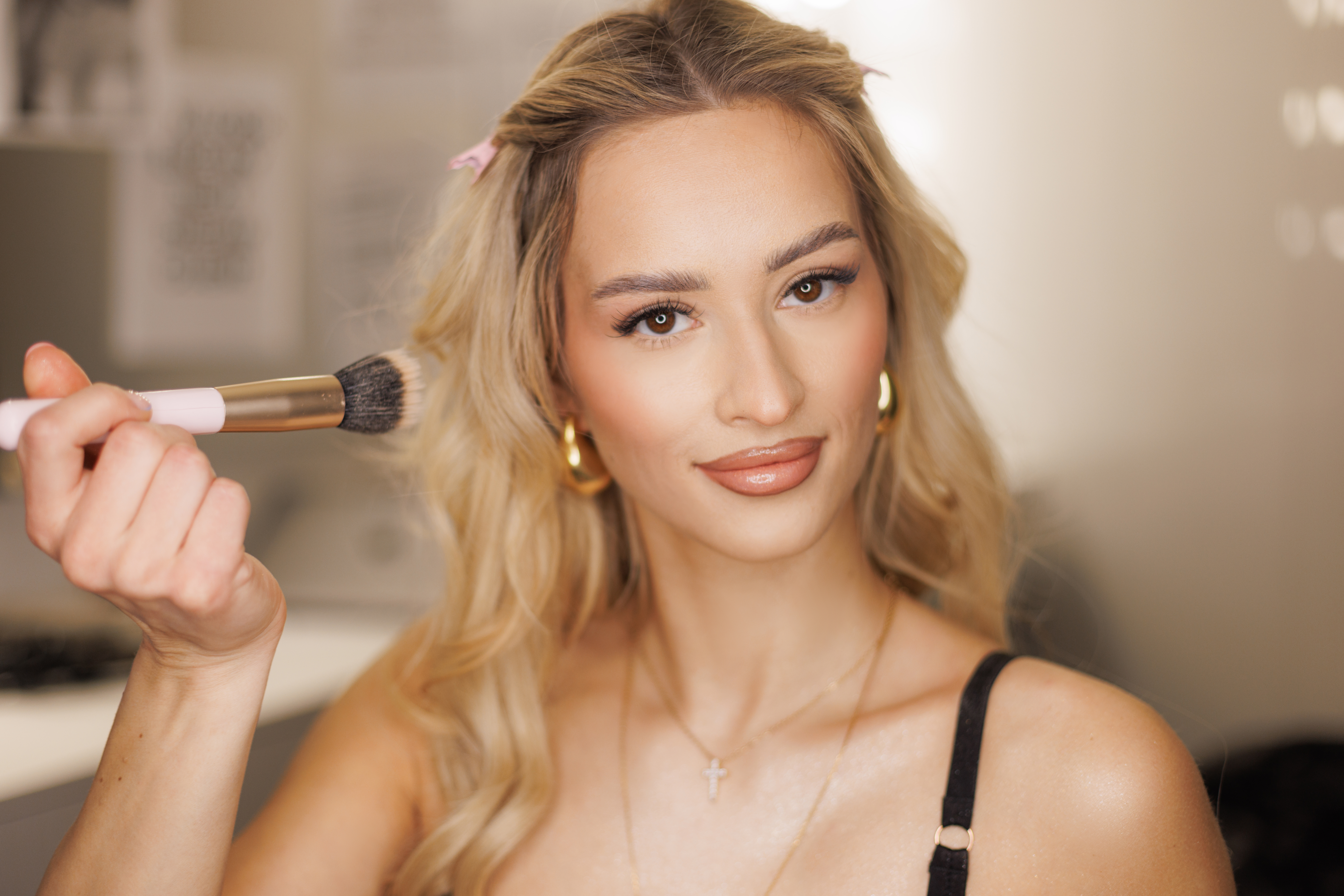Beautiful fresh blonde happy woman with clear skin doing makeup
