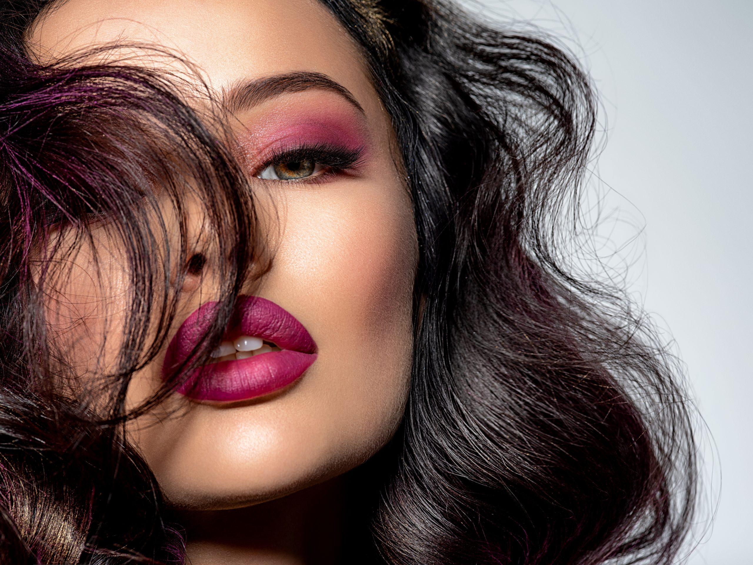 Portrait of beautiful young woman with bright maroon makeup. Bea