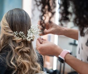 Hairstylist creating a bridal hairstyle with flowers.