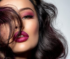 Portrait of beautiful young woman with bright maroon makeup. Bea